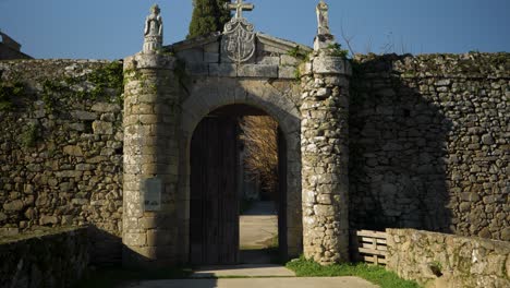 smooth dolly along pathway entrance to monastery of san salvador de ferreira wooden doors