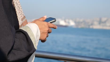 person using a smartphone by the water