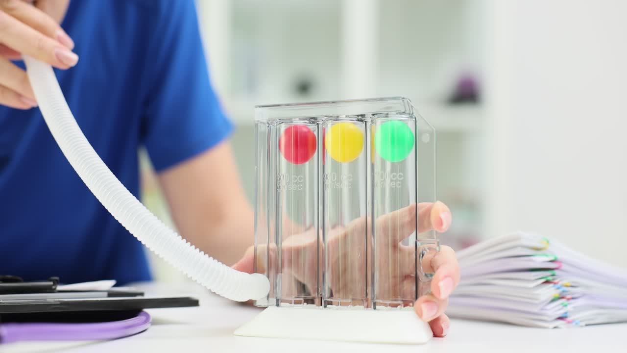 Person Using a Spirometer for Breathing Exercise