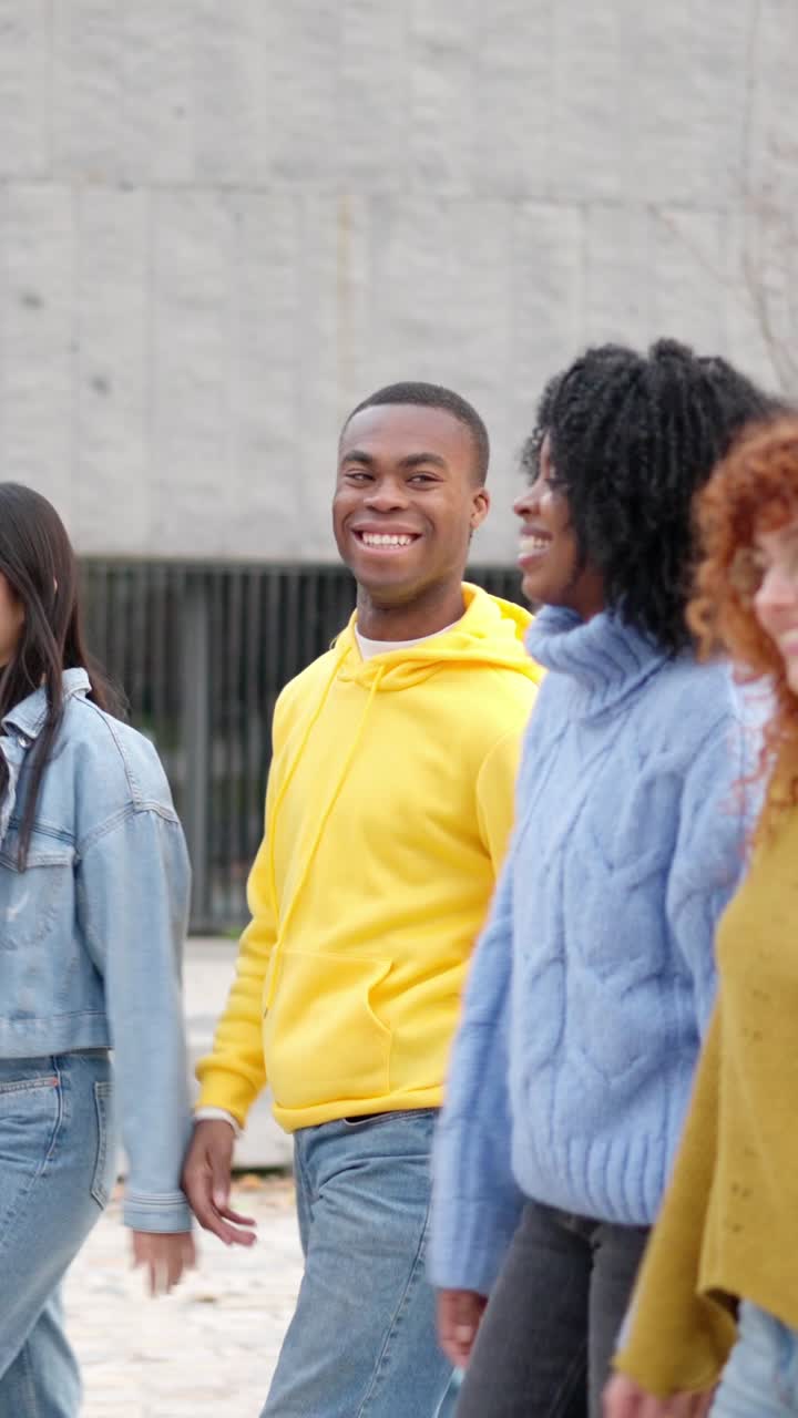 Multiracial friends smiling while strolling along the street