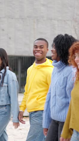multiracial friends smiling while strolling along the street