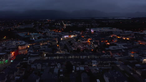Slide-and-pan-shot-of-colourful-buildings-in-evening-town.-Aerial-shot-of-city-centre-after-sunset.-Killarney,-Ireland
