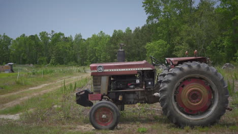 Tractor-sitting-outside-in-a-field-on-a-sunny-day-on-a-farm