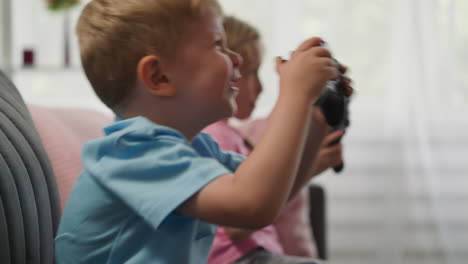 blond toddler talks while playing video game with sister