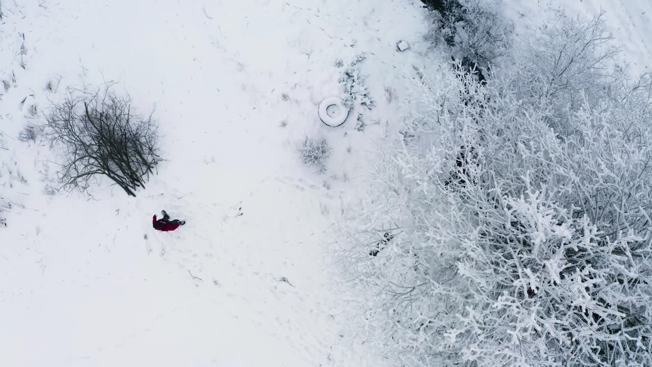 Boscaiolo che accatasta rami d'albero mentre disbosca un fosso, inverno.
