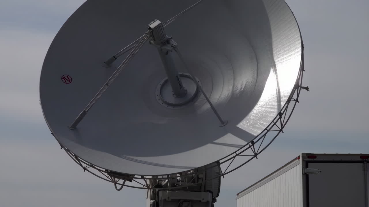 Large Satellite Dish and Truck Against Sky