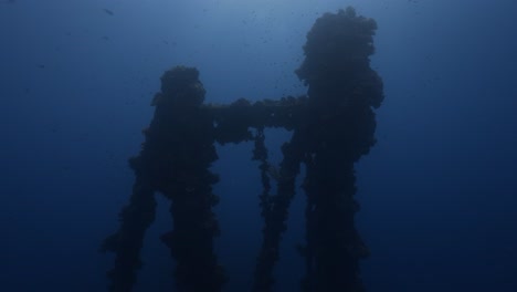 Backlight-shot-of-a-Shipwreck-underwater-structure-in-clear-blue-water-of-Palau,-Micronesia,-pacific-ocean