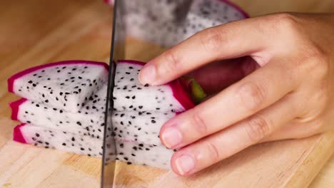 hands slicing dragon fruit into even pieces