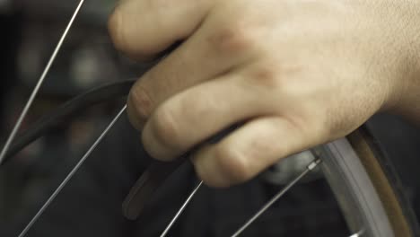 a bicycle mechanic inflating a bicycle wheel