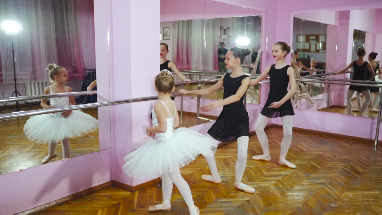 Three Young and Graceful Ballerinas Practicing Their Dance. They Wear Black Tutus and White Tights. Shot in a Modern Studio. In Slow Motion.