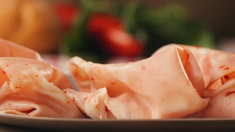 ham italian mordatella, man slices of traditional italian antipasti mortadella sausage on a wooden cutting board, close up macro of chicken or turkey jamon, fat breakfast dish.