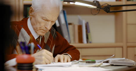 empresario senior escribiendo en papel en la mesa en la oficina 8