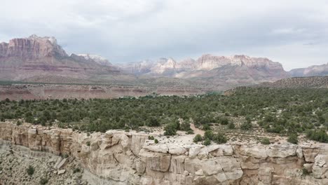 outskirts of zion national park utah with sandstone mountains and canyon, aerial dolly out reveal shot