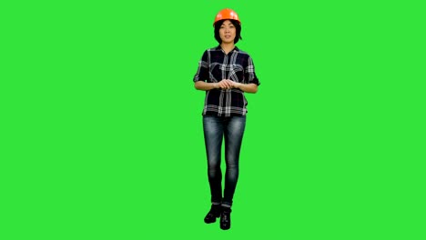 asian engineer with helmet talk to a camera on a green screen, chroma key