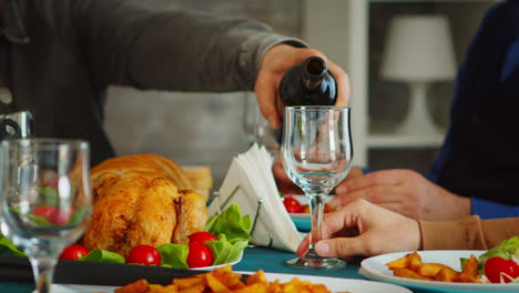 close up of young man pouring red wine