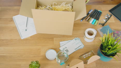 overhead shot of woman running online business making candles packaging them for dispatch