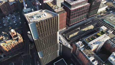 Aerial-drone-flight-over-the-rooftops-of-Oxford-Road-in-Manchester-City-Centre-showing-the-streets-below