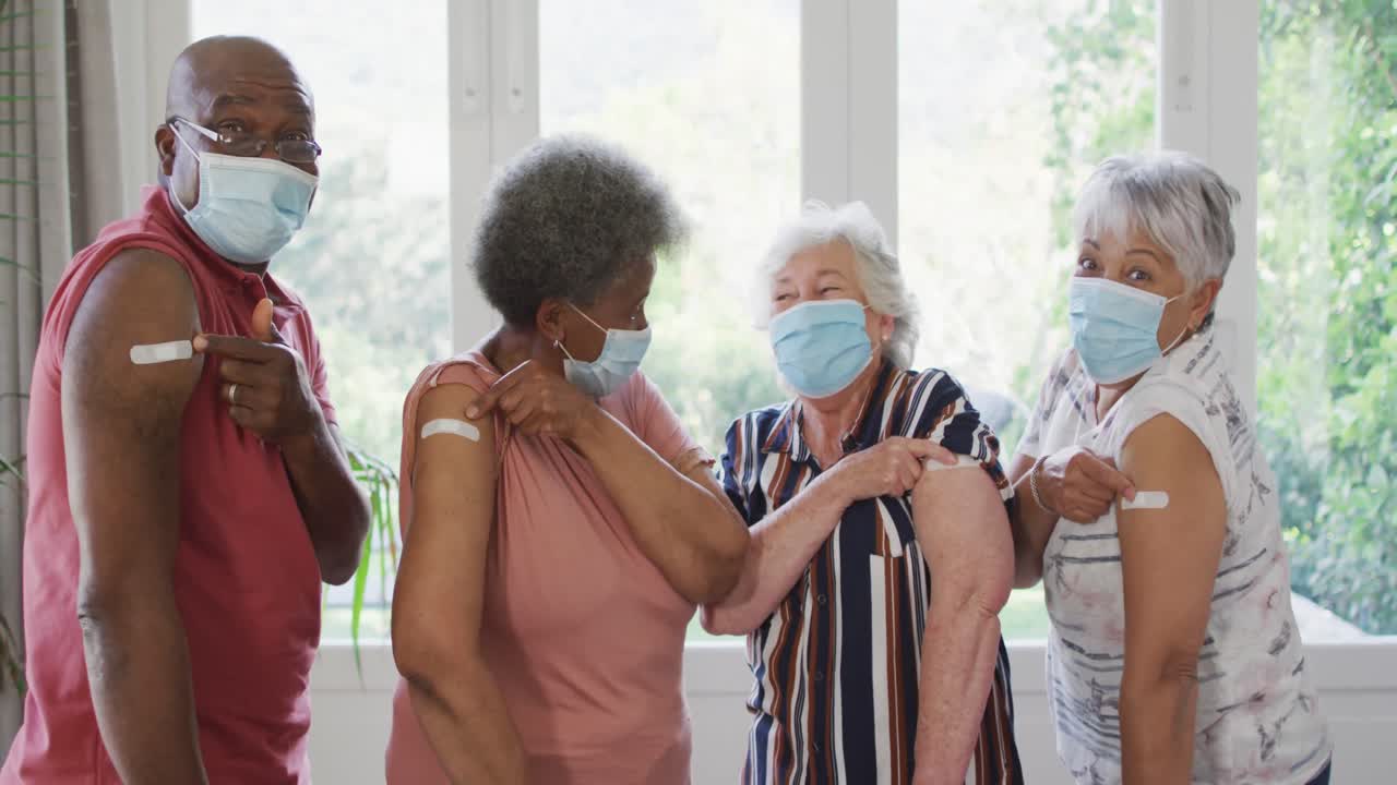 코로나바이러스 백신 접종 후 팔에 플래스터를 보여주는 다양한 고령 친구 그룹