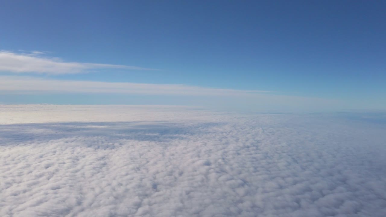 Aerial above flat cloud layer with blue sky