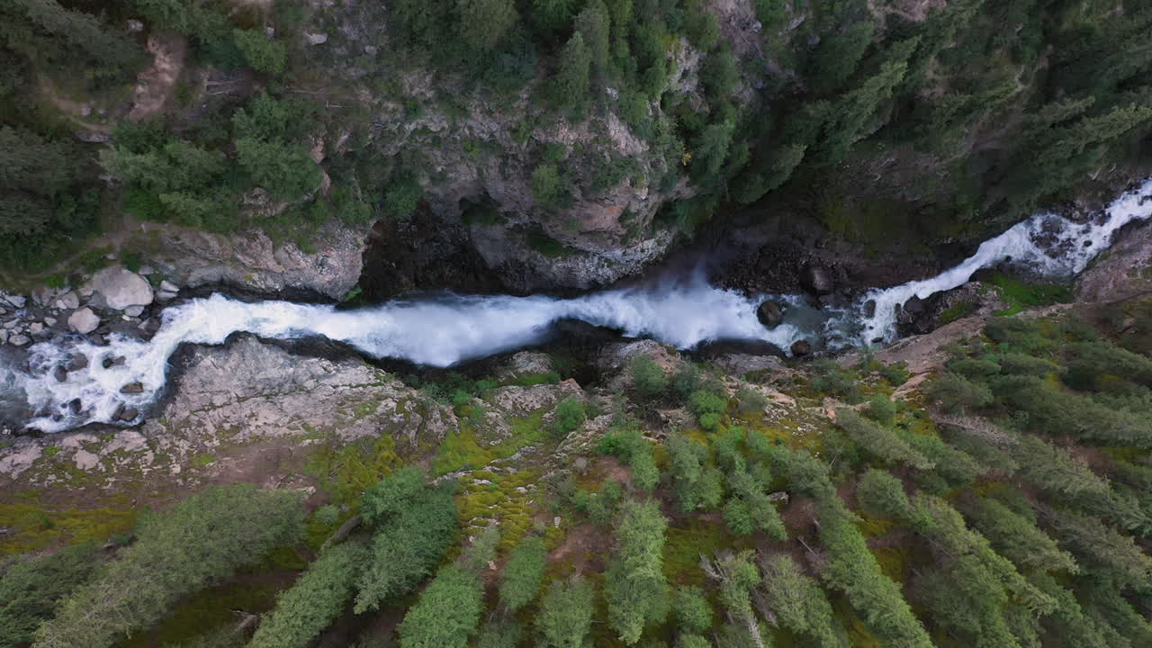 tiro aéreo de ángulo descendente cascada barskoon en el cañón de cuento de hadas en kirguistán, imágenes cinematográficas de drones descendentes