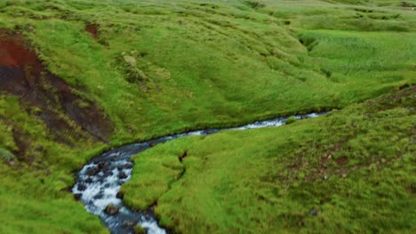 drone flyover greenery landscape with hveragerdi hot springs river in reykjadalur, iceland