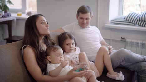 mom and dad spending time with kids on sofa