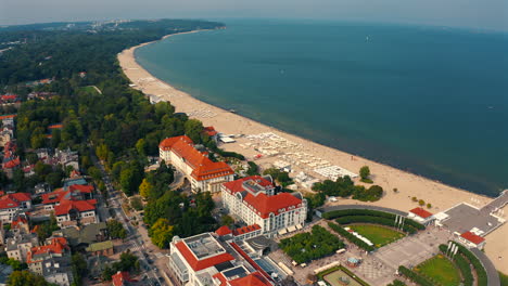 aerial view of drone flying above sopot city towards the monciak pier with baltic sea in the background