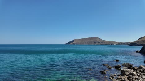 Crystal-clear-waters-and-rocky-shores-highlight-the-tranquil-beauty-of-Crimea's-coastline-on-a-sunny-day