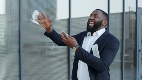 businessman throwing money at street. executive celebrating victory with cash