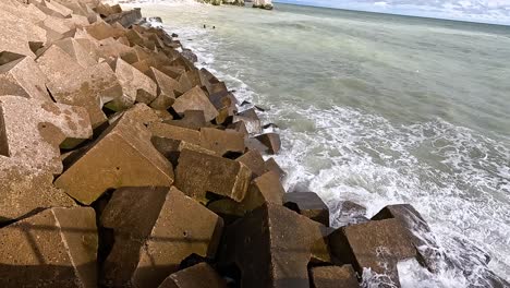 waves hitting concrete blocks on the shore