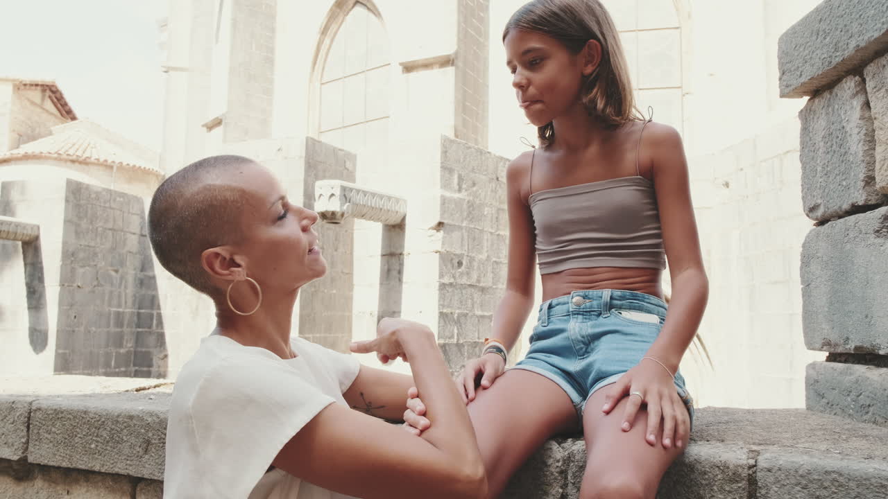 Donna e ragazza che parlano e sorridono in una città antica