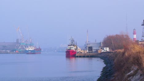 안개 낀 날 리파자 항구에 있는 대형 파란색 화물선과 어선, 안개가 낀 고요한 날, 먼 중간 샷