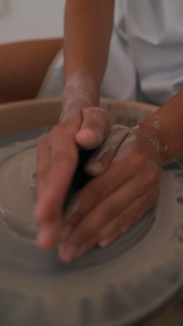 manos moldeando arcilla en una rueda de cerámica