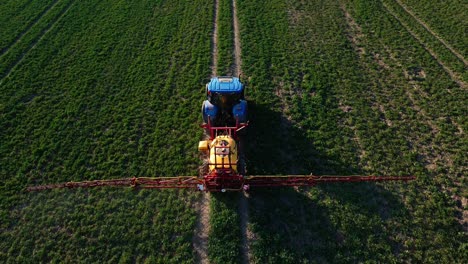 tractor spray fertilizer on agricultural field, aerial view