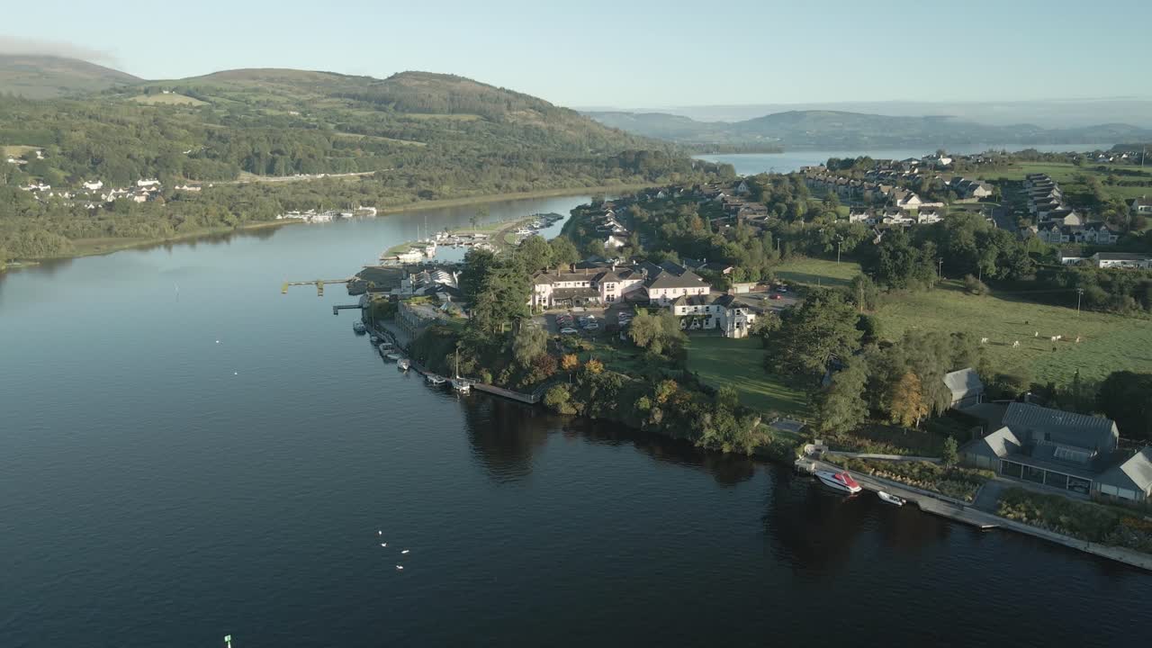 Killaloe town along a peaceful river with lush hills in county limerick, ireland, aerial view