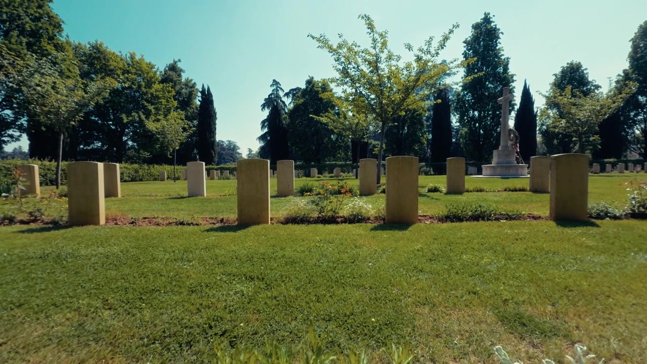 Prato di cimitero illuminato dal sole con lapidi