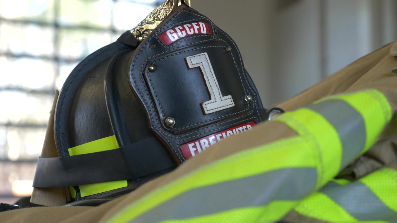 Casco da pompiere nero sopra una giacca antincendio protettiva all'interno di una caserma dei pompieri