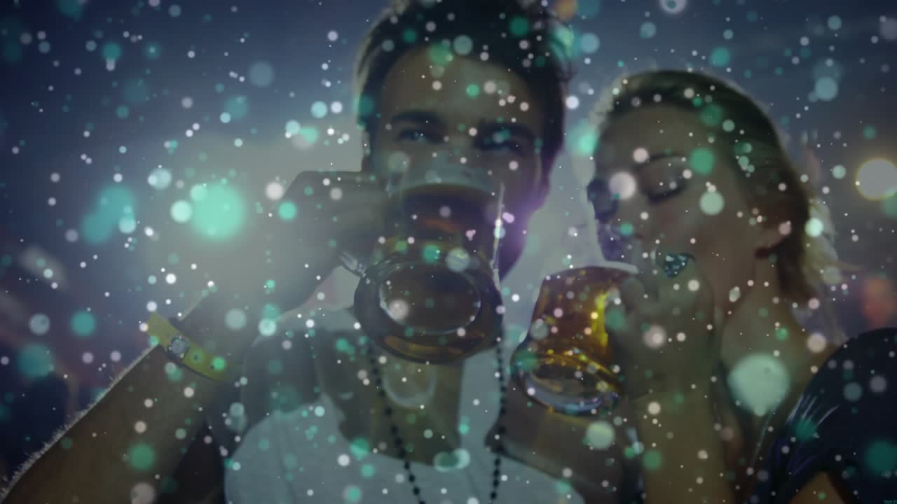 Pair sipping mugs in club, performer drawing man moving right, bokeh overlay partly hiding faces