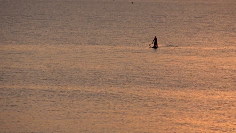 Sonnenuntergangschattenbild-Des-Mannes-Auf-Paddelbrett