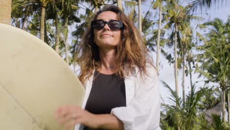 mujer posando con una tabla de surf