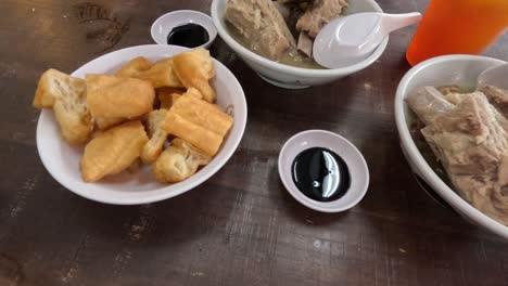 serving and enjoying bak kut teh soup