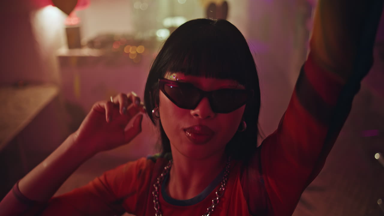 Club dancer moving body in sunglasses at vibrant nightclub atmosphere closeup