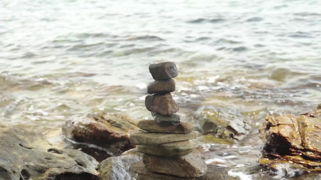 Un momento di tranquillità mentre dolci onde oceaniche si infrangono contro le rocce impilate circostanti