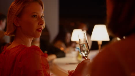 una chica hermosa bebiendo champán en un bar.