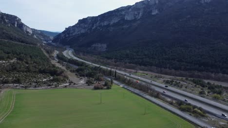 Rotating-aerial-with-vehicles-driving-on-highway-thru-mountain-pass