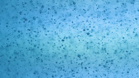 multitude of blue bubbles in sparkling water, light-colored background, packshot