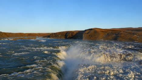 vista aérea de la cascada congelada de urriðafoss en islandia con el río salvaje