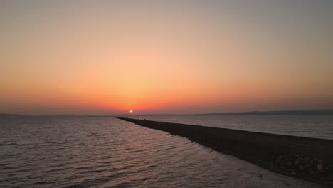 a stunning top drone view of a car cruising on the road to heaven in kutch, gujarat, a scenic highway flanked by the sea on both sides. the golden sunset reflects beautifully