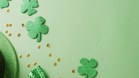 video of saint patricks day green shamrock, hat and bow tie with copy space on green background