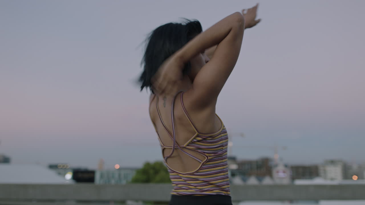 mujer bailarina atractiva bailarina callejera hispana en la ciudad realizando movimientos contemporáneos de hip hop disfrutando de la expresión de danza moderna al atardecer de cerca